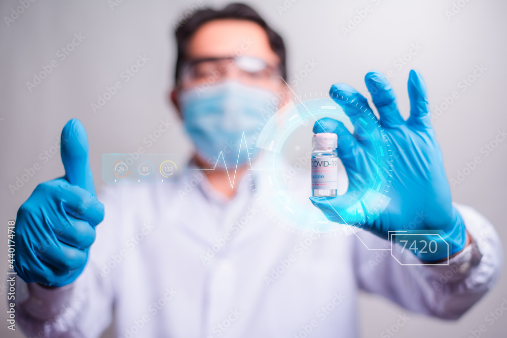 Doctor holding vaccine bottle with modern HUD interface screen on hospital background, Innovation and Medical technology. Doctor holding vaccine bottle with modern HUD interface screen on hospital background, Innovation and Medical technology.