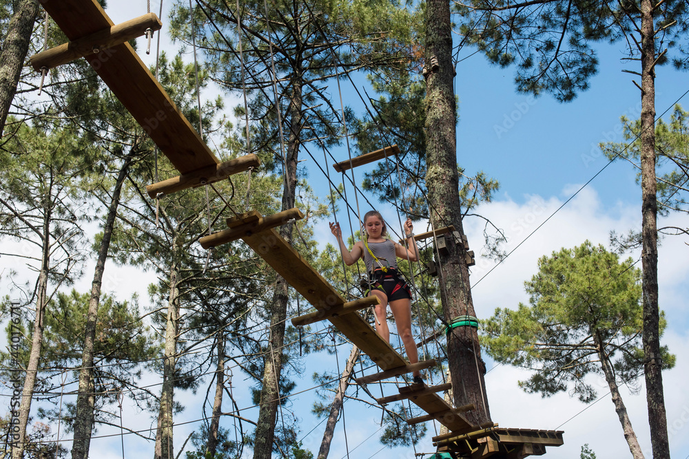 pretty young woman in an extreme tree climbing course