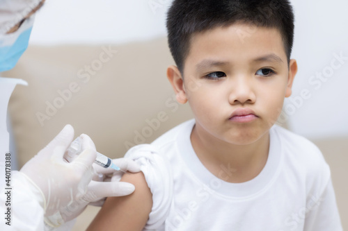 Doctor vaccinating Asian little boy at doctor's office © Keopaserth