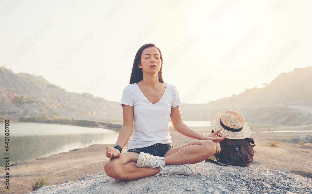 Unity with nature. young woman doing meditating outdoors near lake or river at sunset, sitting in lotus pose and meditating on the background of nature. healthy lifestyle and yoga concept. Unity with nature. young woman doing meditating outdoors near lake or river at sunset, sitting in lotus pose and meditating on the background of nature. healthy lifestyle and yoga concept.