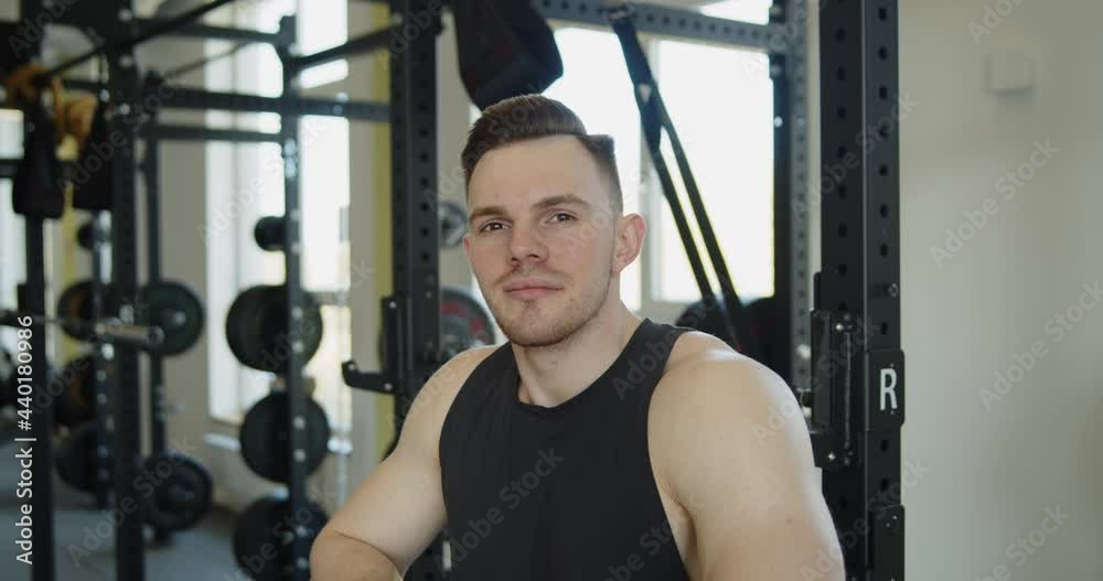 Young attractive muscular athlete stand in front of the exercise machines looking at the camera. Active healthy lifestyle and wellbeing. Young attractive muscular athlete stand in front of the exercise machines looking at the camera. Active healthy lifestyle and wellbeing.