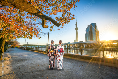 Two asian women walking acros  Sumida river canal in Asakusa,Tokyo. Japan photo