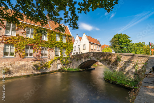 Traditional stone bridge and medieval architecture near Bruges canal. Belgium