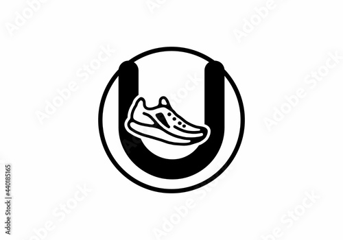 Black U initial letter with shoes in circle