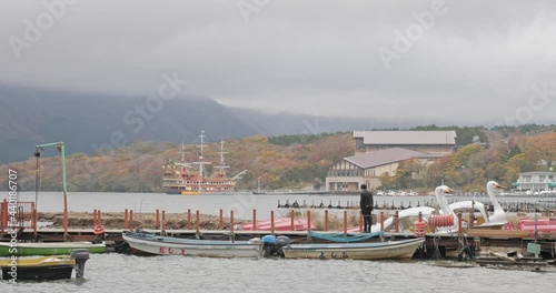 Young man standing at the port of lake in Japan. photo