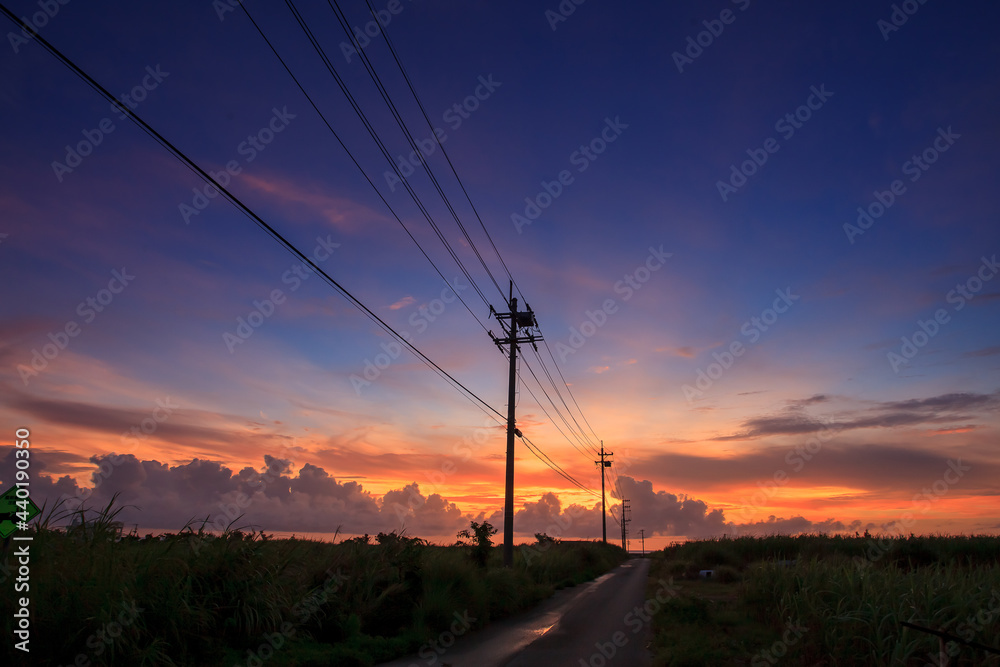 A magical and beautiful dusk cloud upon a country road with many telephone poles