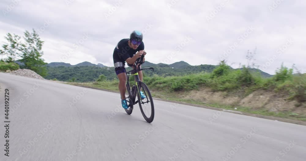 triathlon athlete riding a bike on curvy country road triathlon athlete riding a bike on curvy country road