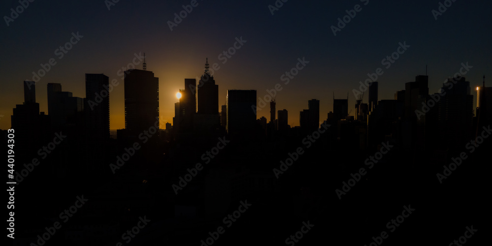 Naklejka premium Melbourne city skyline silhouetted by a dramatic sunset