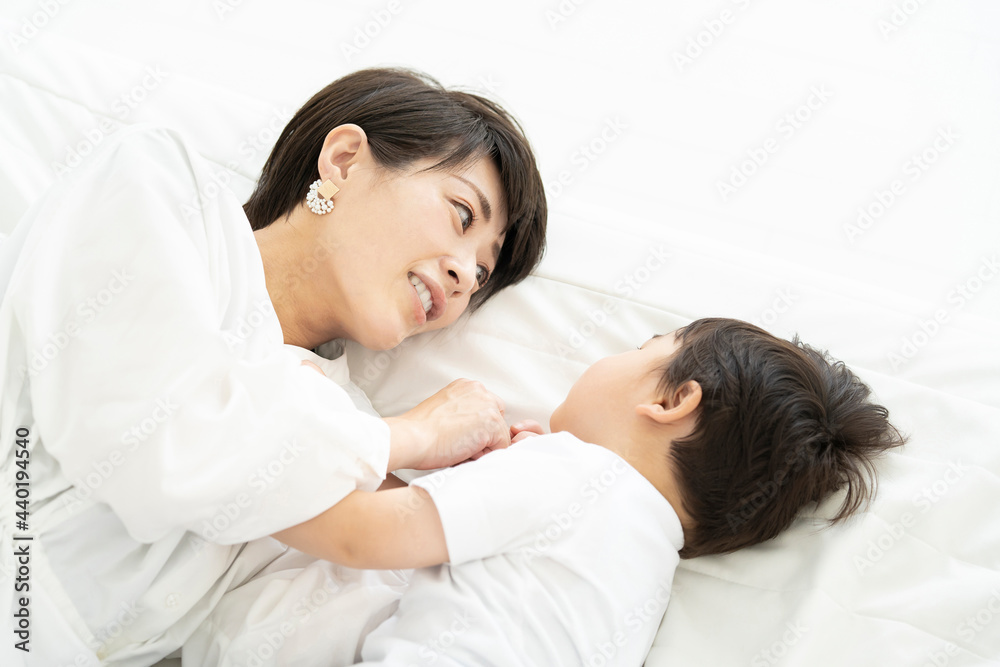 寝転んで戯れるお母さんと男の子 寝転んで戯れるお母さんと男の子