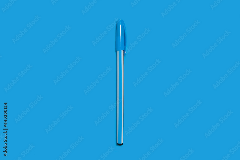 light blue plastic pen on dark-blue background. office accessorize