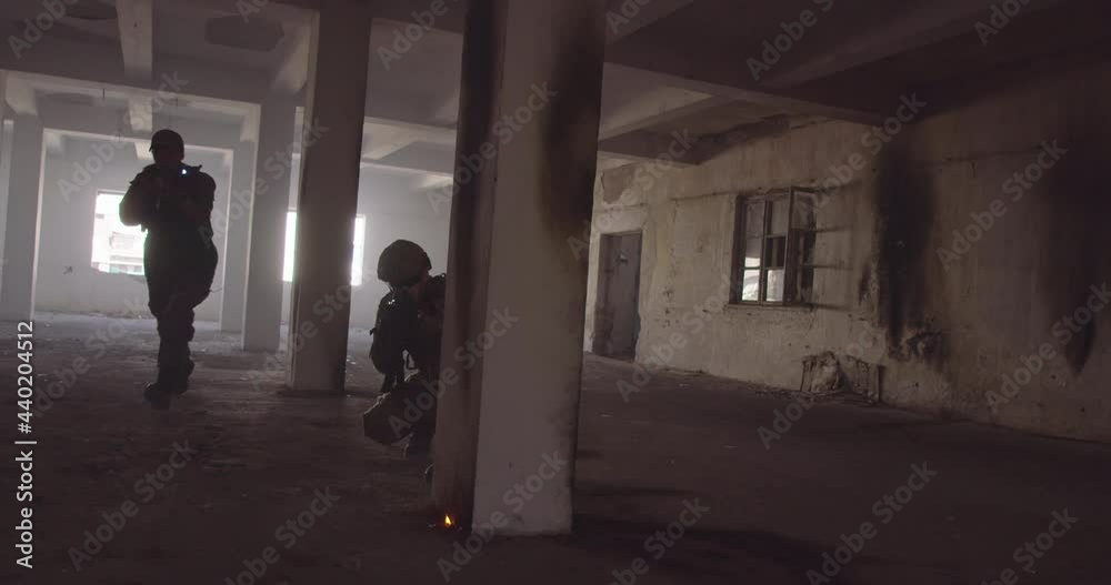 Masked Team of Armed Modern Warfare Soldiers Team Move in Tactical Formation in a Dark Urban Battlefield Indoors.Soldiers Squad with Rifles and Flashlights in action. Masked Team of Armed Modern Warfare Soldiers Team Move in Tactical Formation in a Dark Urban Battlefield Indoors.Soldiers Squad with Rifles and Flashlights in action.