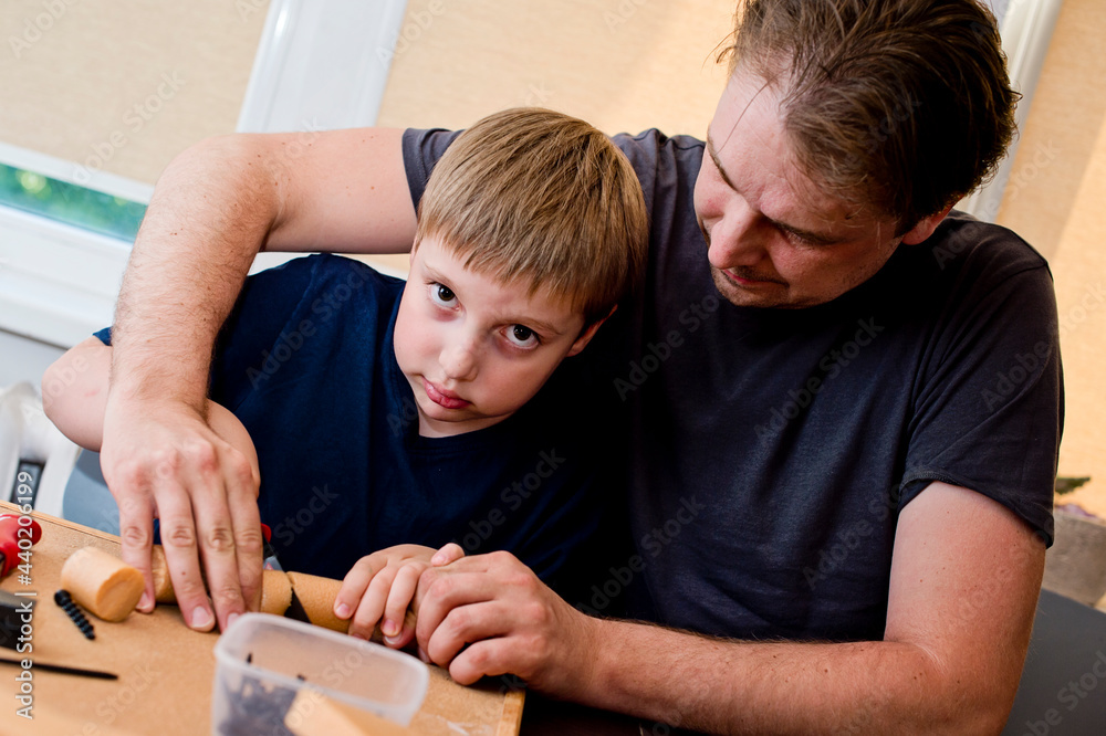 Building relations. Father-child interactions. Activities at home. Boy and father Playing with DIY Toys Carpentry Construction Engineering Tool Workshop Kit. 