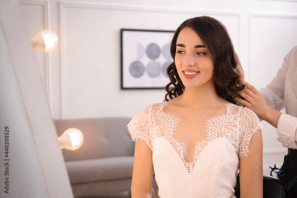 Stylist working with client in salon, making wedding hairstyle Stylist working with client in salon, making wedding hairstyle