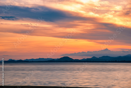 Beautiful cloudscape and dramatic sunset over mountain and sea. © nuttawutnuy