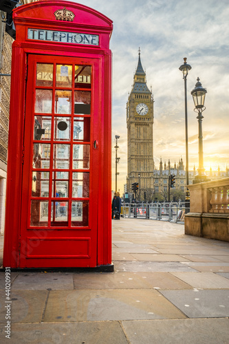 Big Ben at sunrise with red telephone booth in London. England