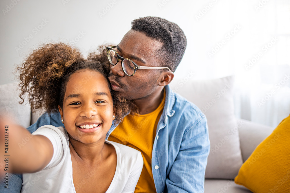 Smiling black father and child daughter taking selfie together looking at camera, head shot portrait of happy african family dad with kid embracing posing making photo recording video, phone cam view Smiling black father and child daughter taking selfie together looking at camera, head shot portrait of happy african family dad with kid embracing posing making photo recording video, phone cam view