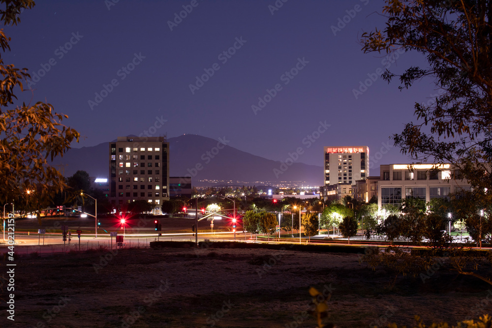 Twilight evening view of traffic streaming by the downtown skyline of Irvine, California, USA.