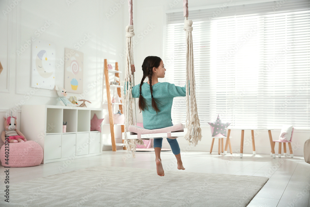 Cute little girl playing on swing at home Cute little girl playing on swing at home