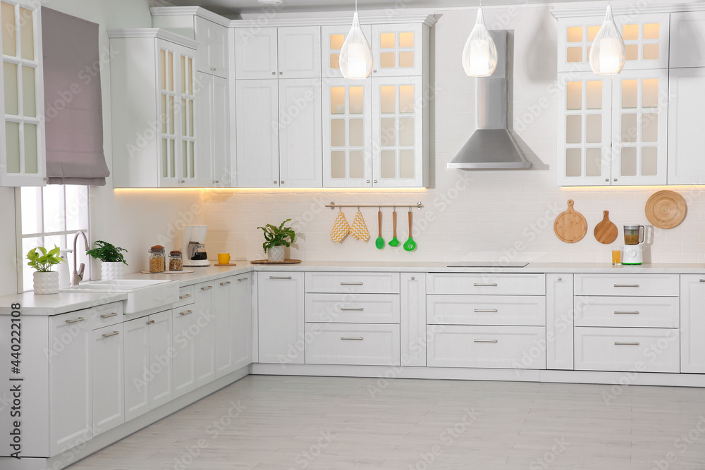 Fototapeta premium Light kitchen interior with stylish furniture and modern equipment