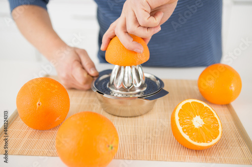 cropped view of hand squeezing orange for juice