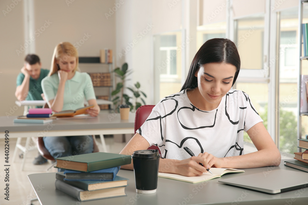 Young woman studying at table in library Young woman studying at table in library