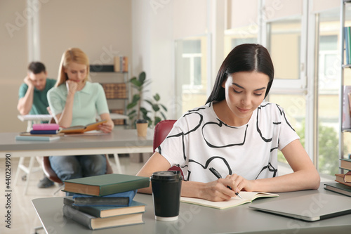Young woman studying at table in library