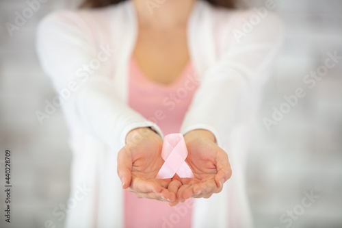 closeup woman hand holding ribbon hiv