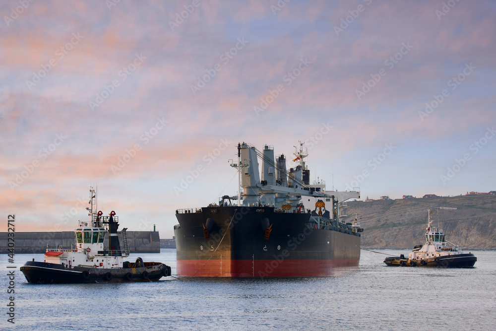 tugboats towing a large ship to enter the port of Bilbao tugboats towing a large ship to enter the port of Bilbao