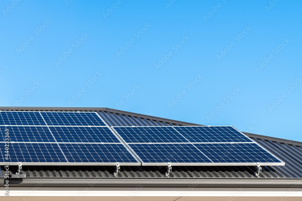 Brand new solar panels on a house roof in Australia on a day against clear blue sky