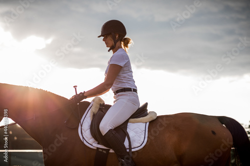 Portrait of young rider in profile against the sky.The concept of healthy lifestyle. Beauty and sports. . Active leisure in nature. Equestrian sports.