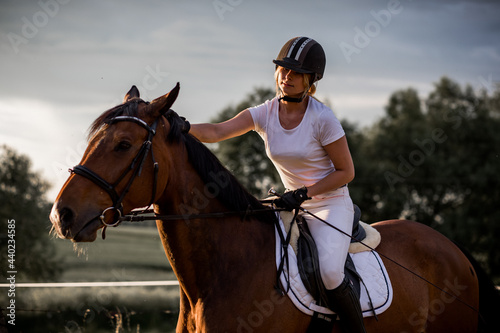 Young woman rides horse in background of nature. Sports and health. Active recreation. Enjoying life.