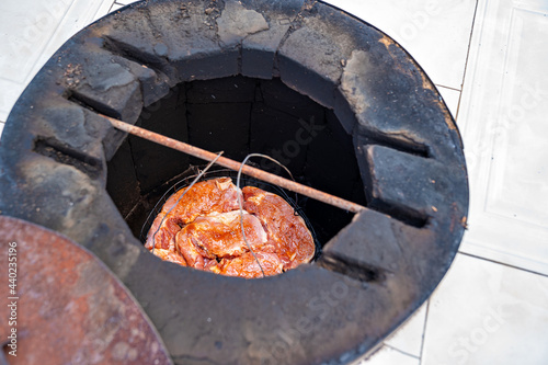 raw marinated meat in spices in a special baking dish in tandoor.