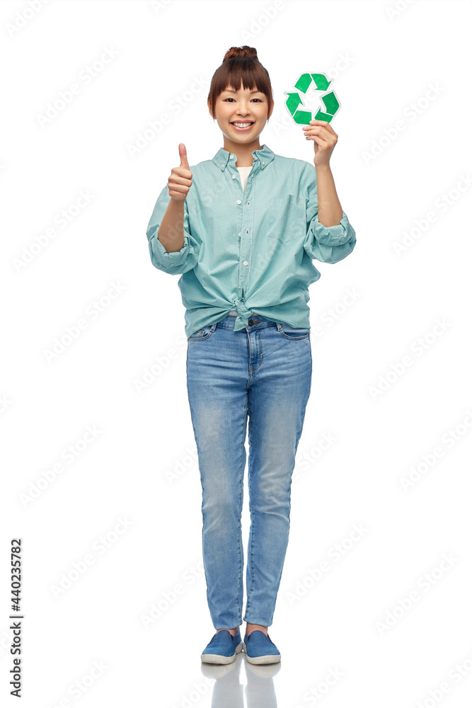 eco living, environment and sustainability concept - portrait of happy smiling young asian woman in turquoise shirt holding green recycling sign showing thumbs up over white background eco living, environment and sustainability concept - portrait of happy smiling young asian woman in turquoise shirt holding green recycling sign showing thumbs up over white background