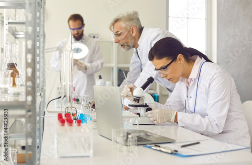Laboratory scientist group working conducting test analysis and experiment using professional lab equipment and glassware. Biochemistry and biotechnology concept. Modern workplace interior