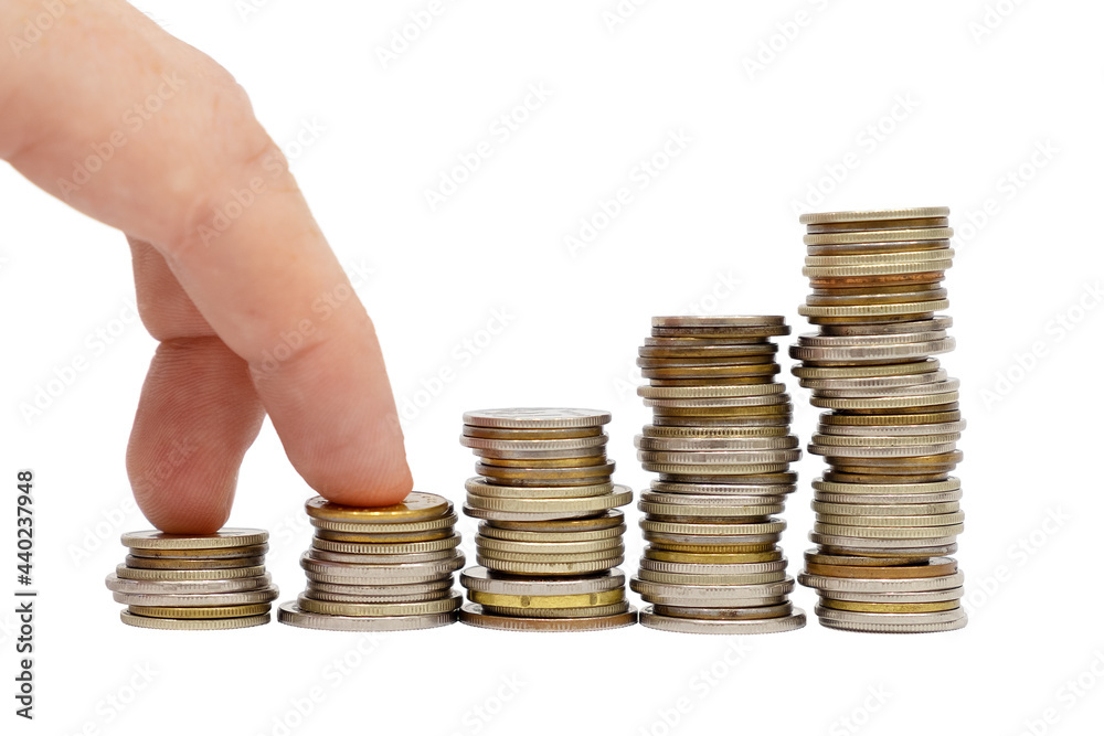 Fingers makes steps on stacks of coins on white background. Money growth and financial goal achievement concept.