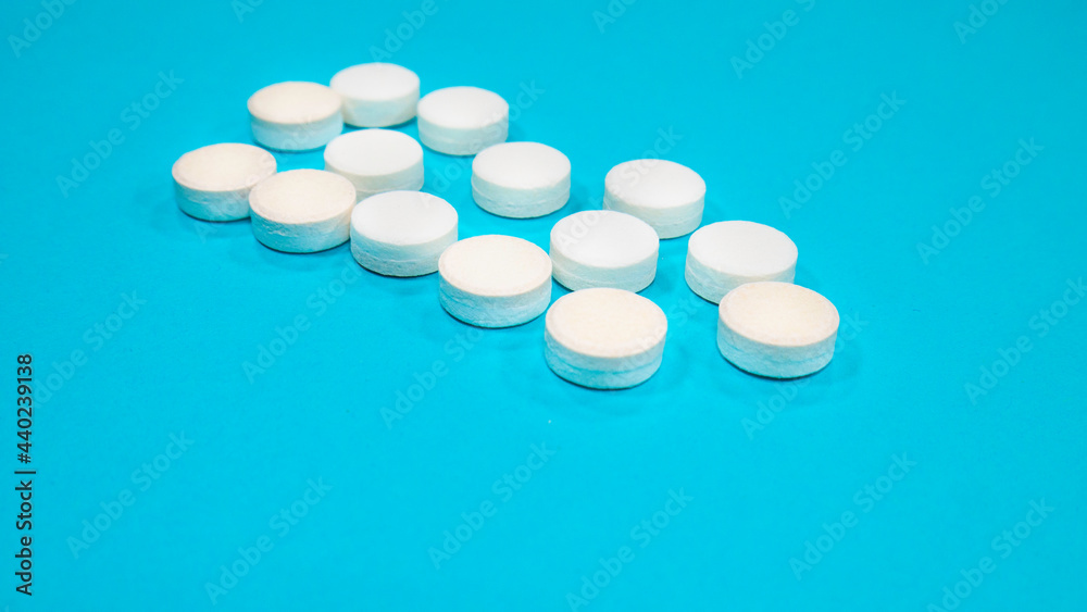 White medical pills on blue background. White medical pills on blue background.