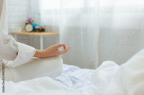 close up of woman hand on bed in white bedroom