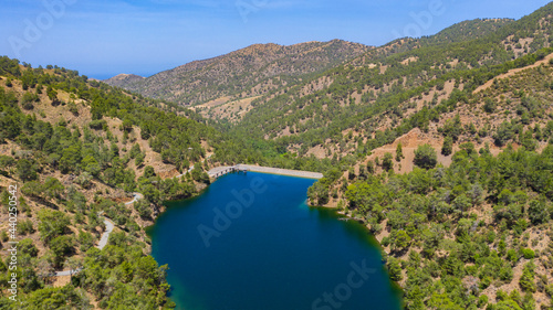 Arminou dam water reservoir in Troodos Mountains, Paphos forest, Cyprus. Aerial view of the earthfill dam, artificial lake