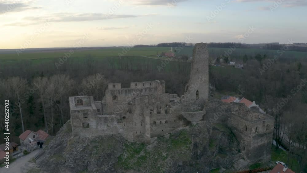 Ruined castle of Okoř on a hilltop in Czech countryside at dusk,aerial.
