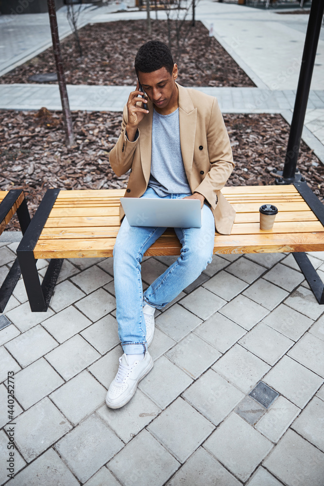 Young dark-skinned male person talking per telephone