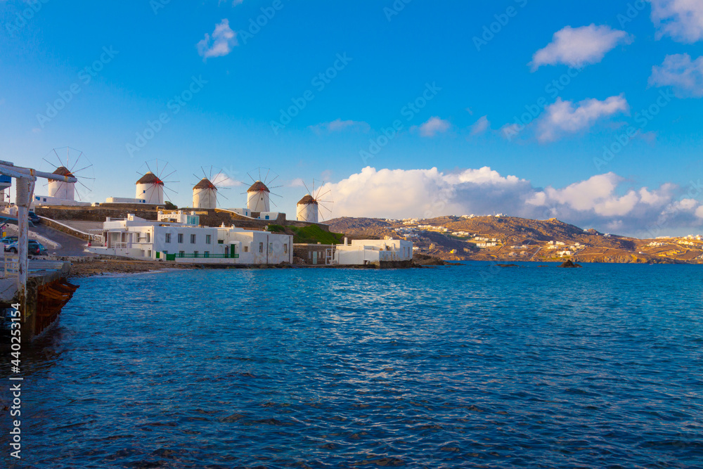 Widnmills view from distance with cloudy sky from the heart of Little Venice in Mykonos Island Cyclades Greece
