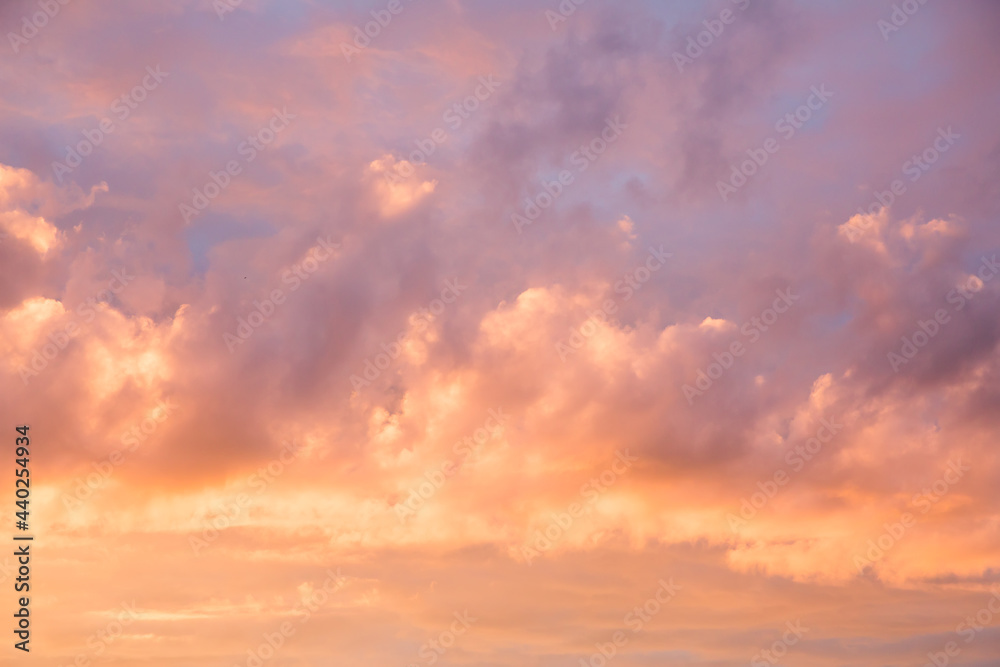 Photo of clouds and sky at sunset. Orange and red shades of sunset light.