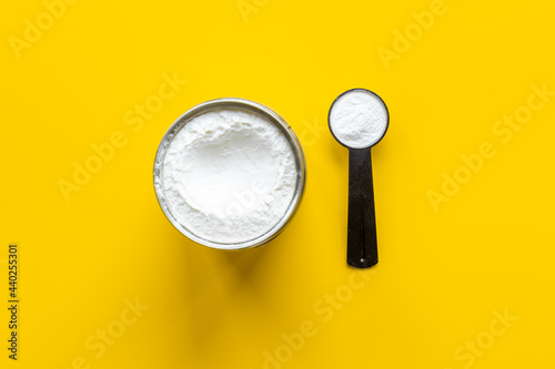 Whey protein powder in scoop and tape measure
