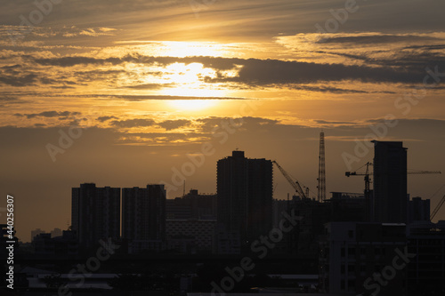 sunset over the city and hight crane work on hight building