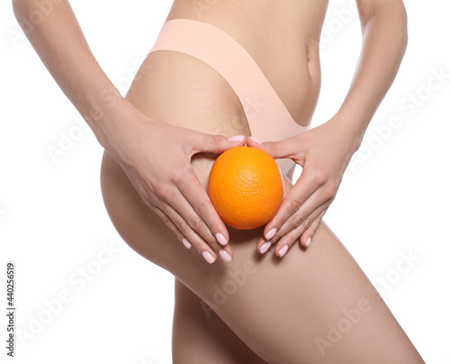 Closeup view of slim woman in underwear with orange on white background. Cellulite problem concept