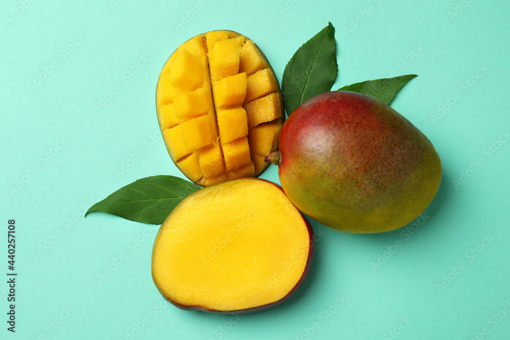 Tasty ripe mango fruit on mint background