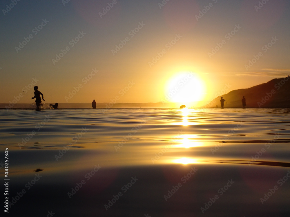 Sunset Over Tide Pool Ripples With Playful Children Silhouettes, South Africa