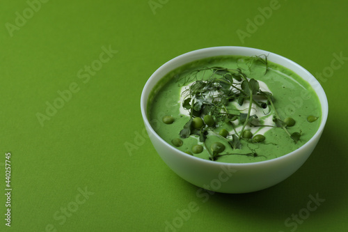 Bowl of pea soup on green background