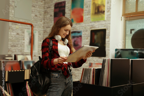 Foto Young woman with vinyl record in store
