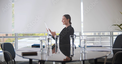 Happy young businesswoman sitting on chair in boardroom